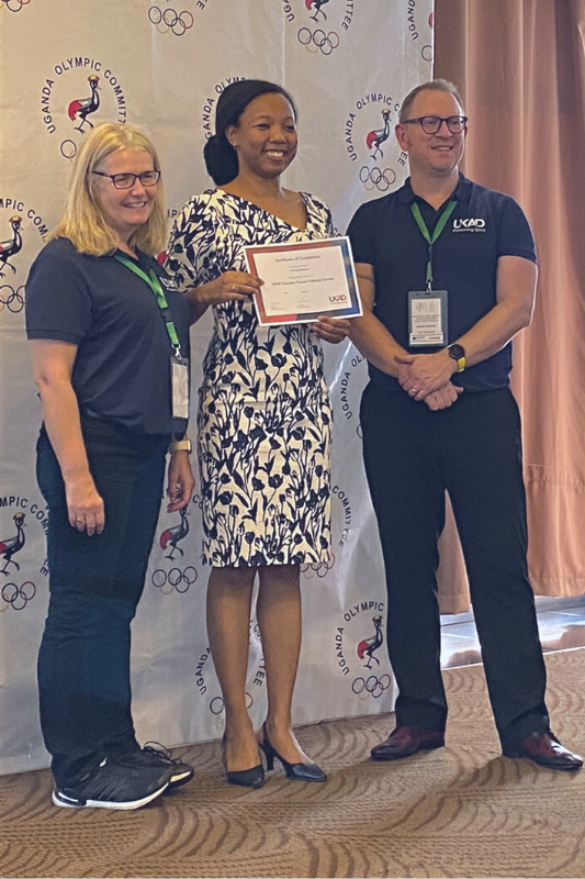 A photo of Dr Aya Nakitanda (centre) receiving her course completion certificate from UKAD trainers Amanda Brook and Anthony Shepherd (left and right)