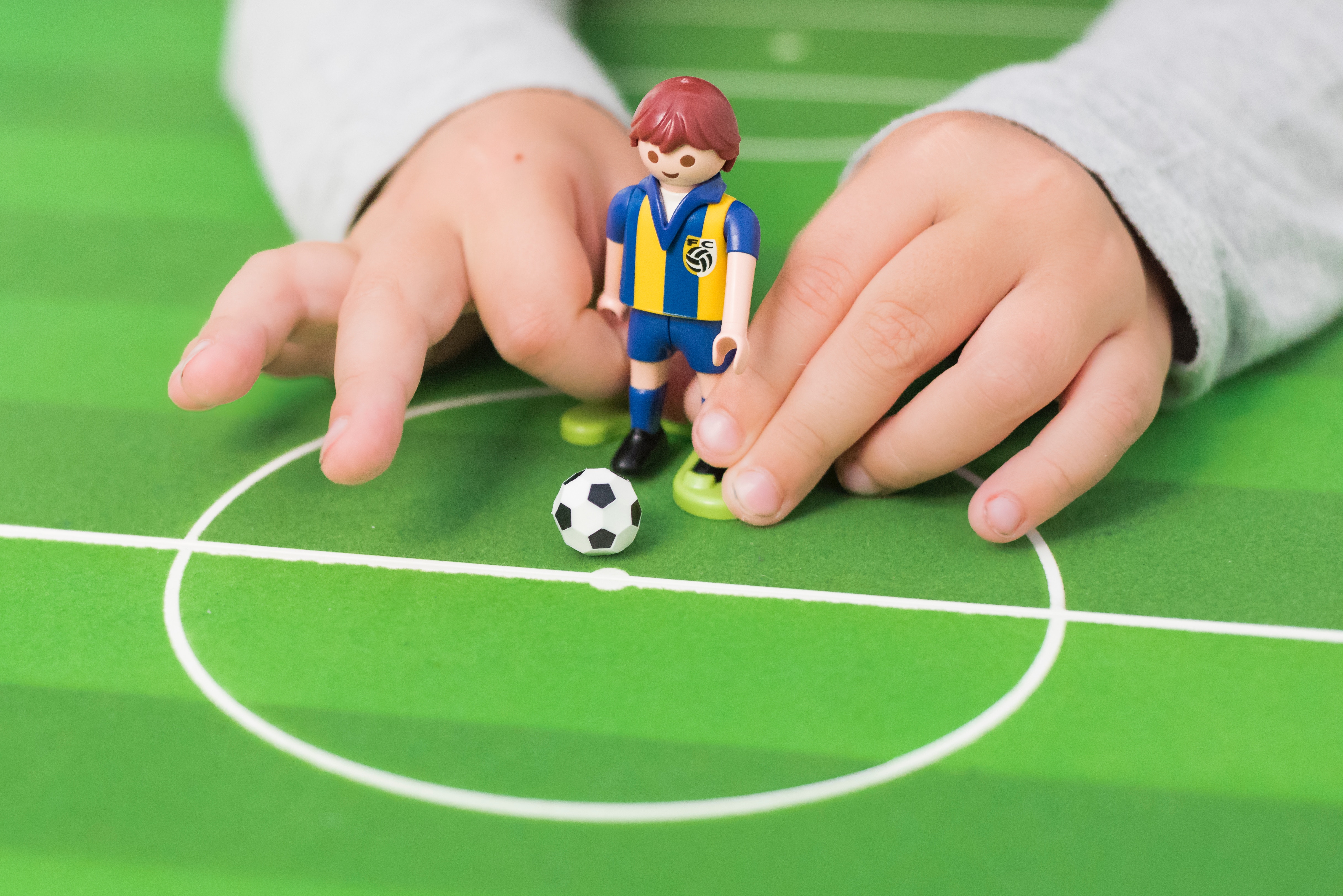 Child playing with a toy football player 