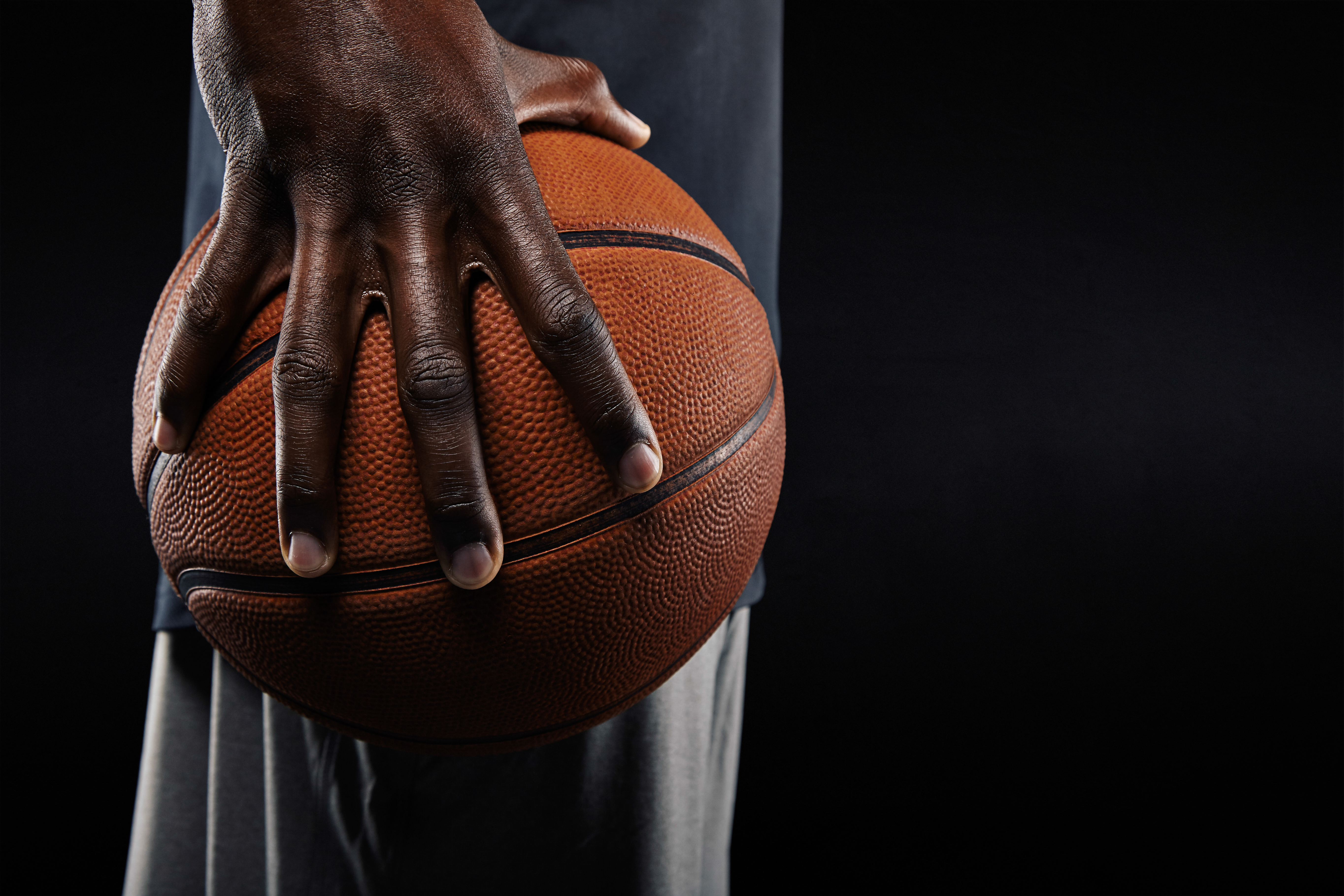 Person holding a basketball by their side