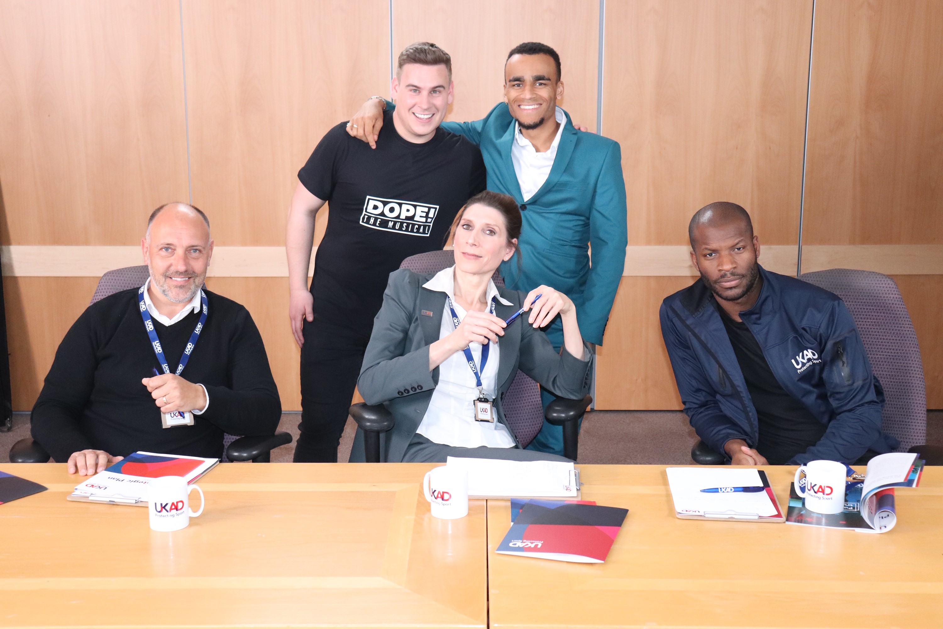 People at a desk looking at the camera