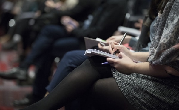 People sitting taking notes at a conference