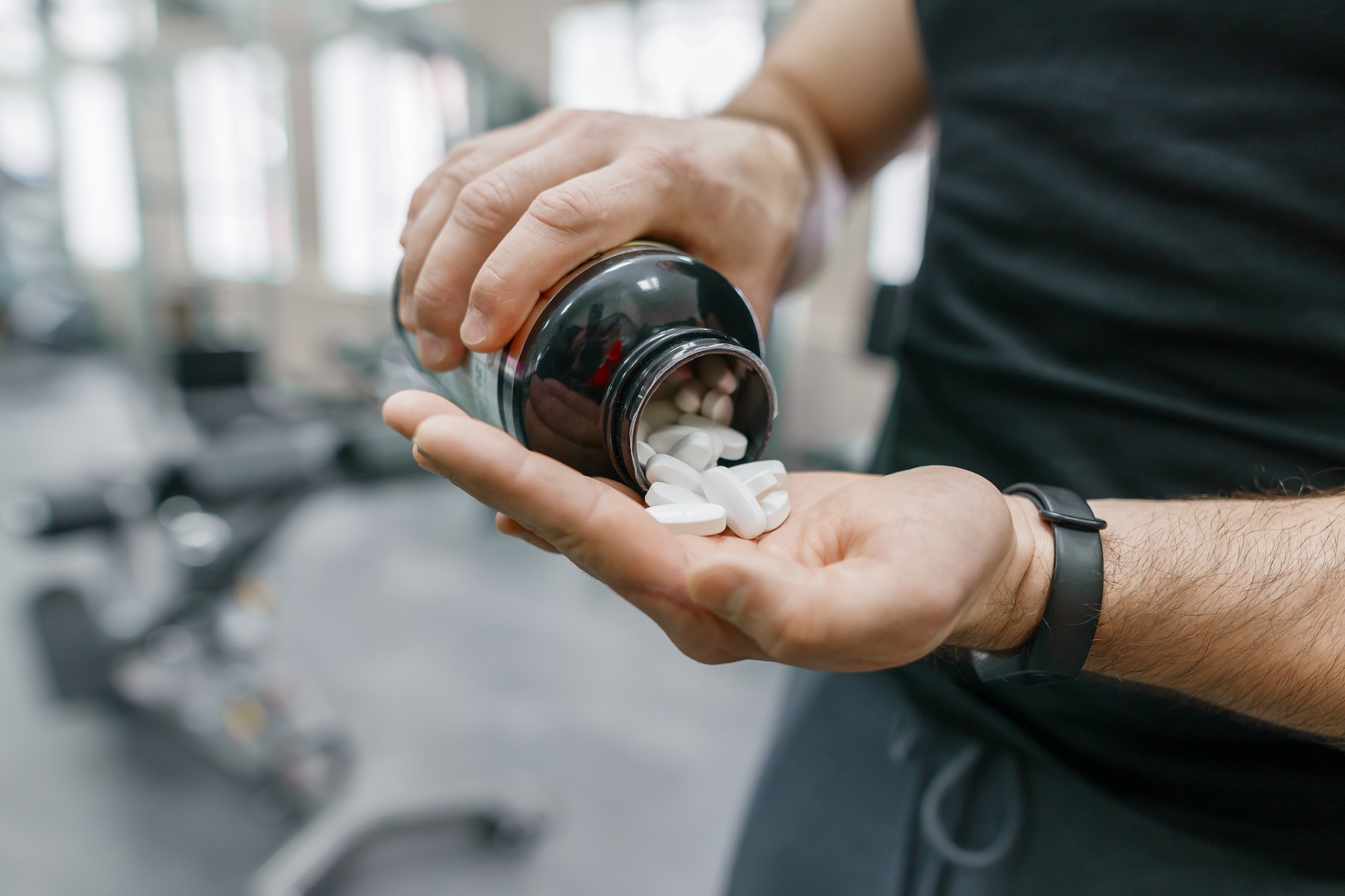 Man pouring supplements (pills) in to his hand