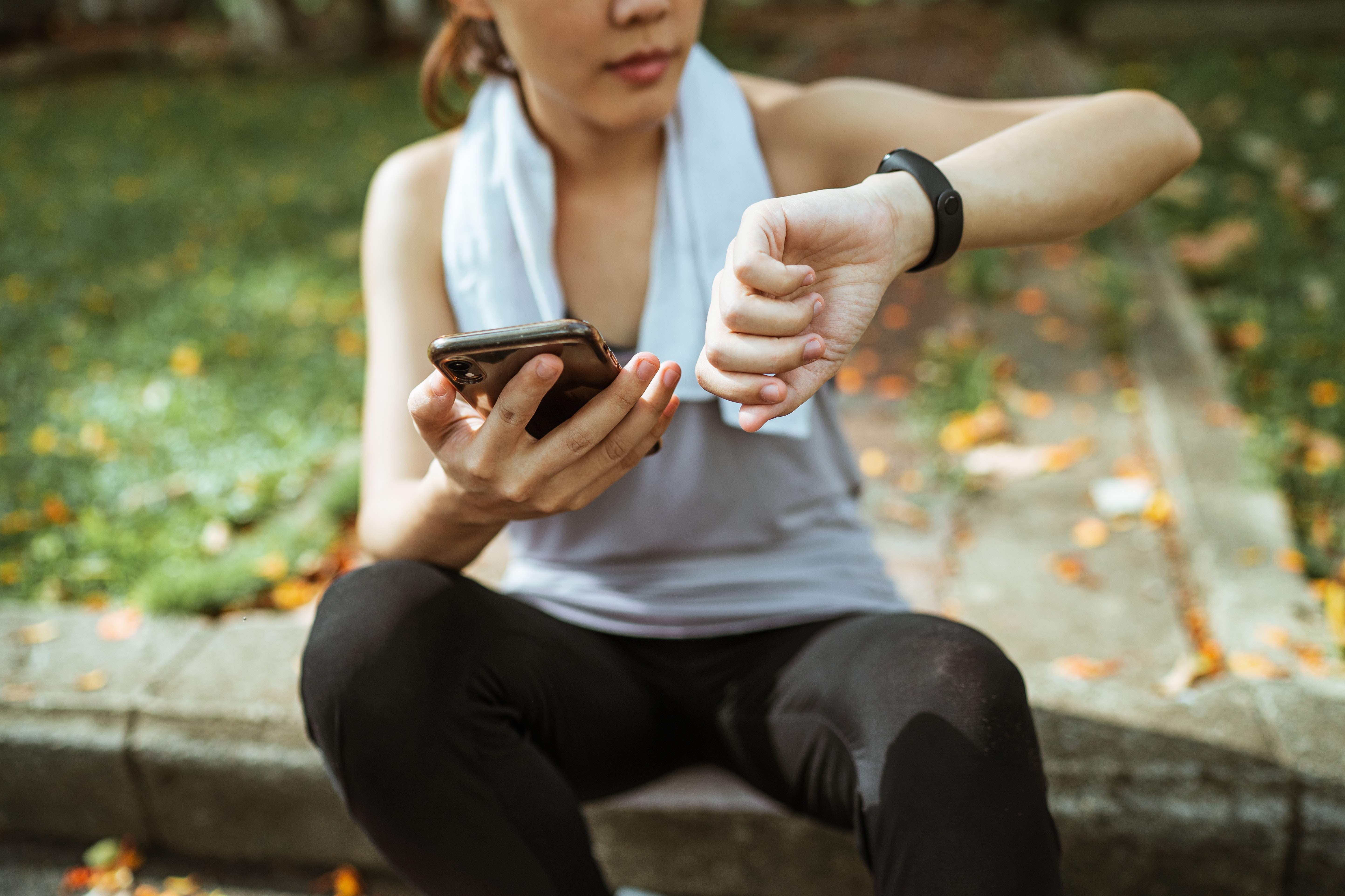 Person checking their phone and active watch