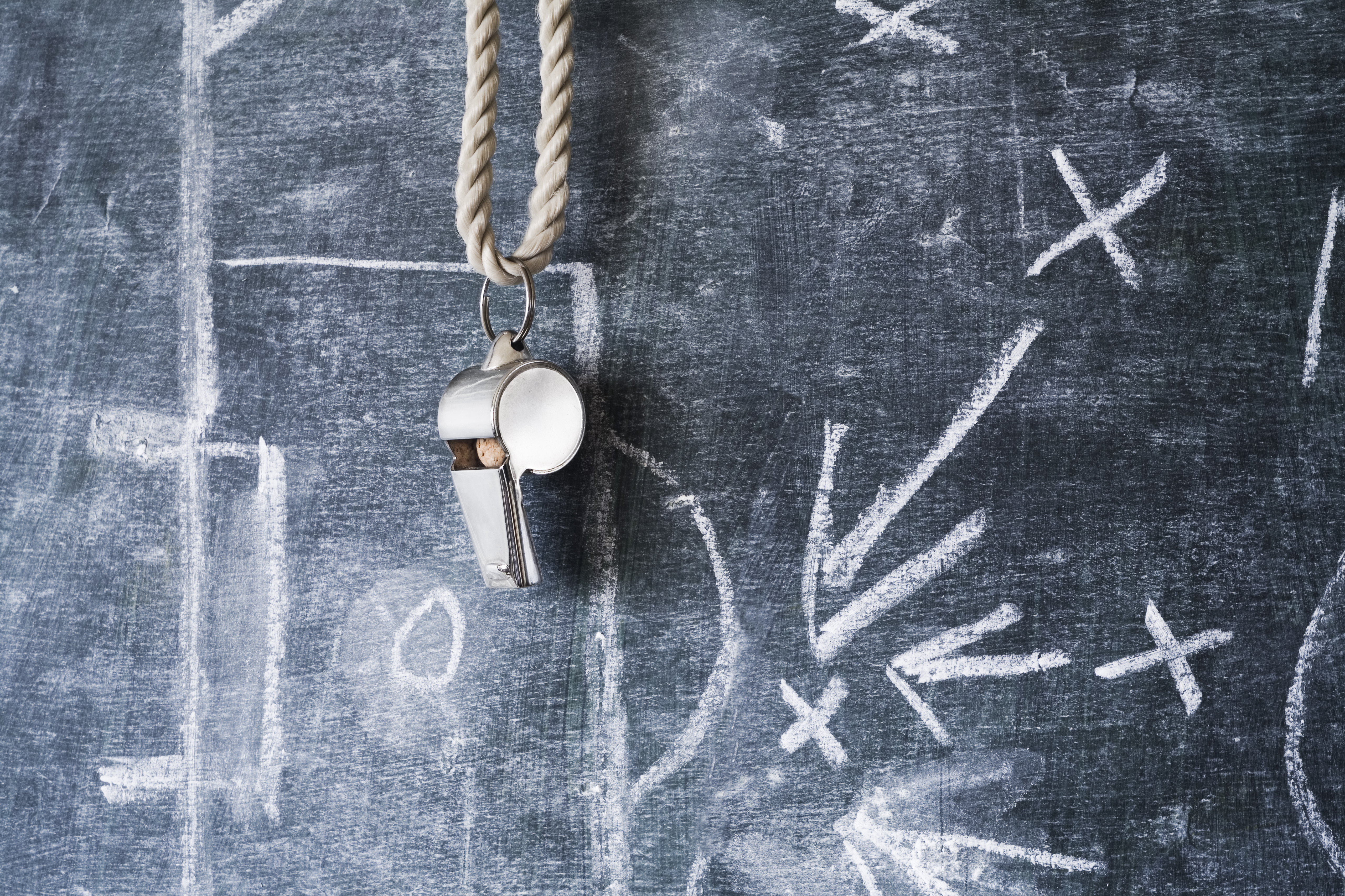 Whistle hanging in front of chalk board