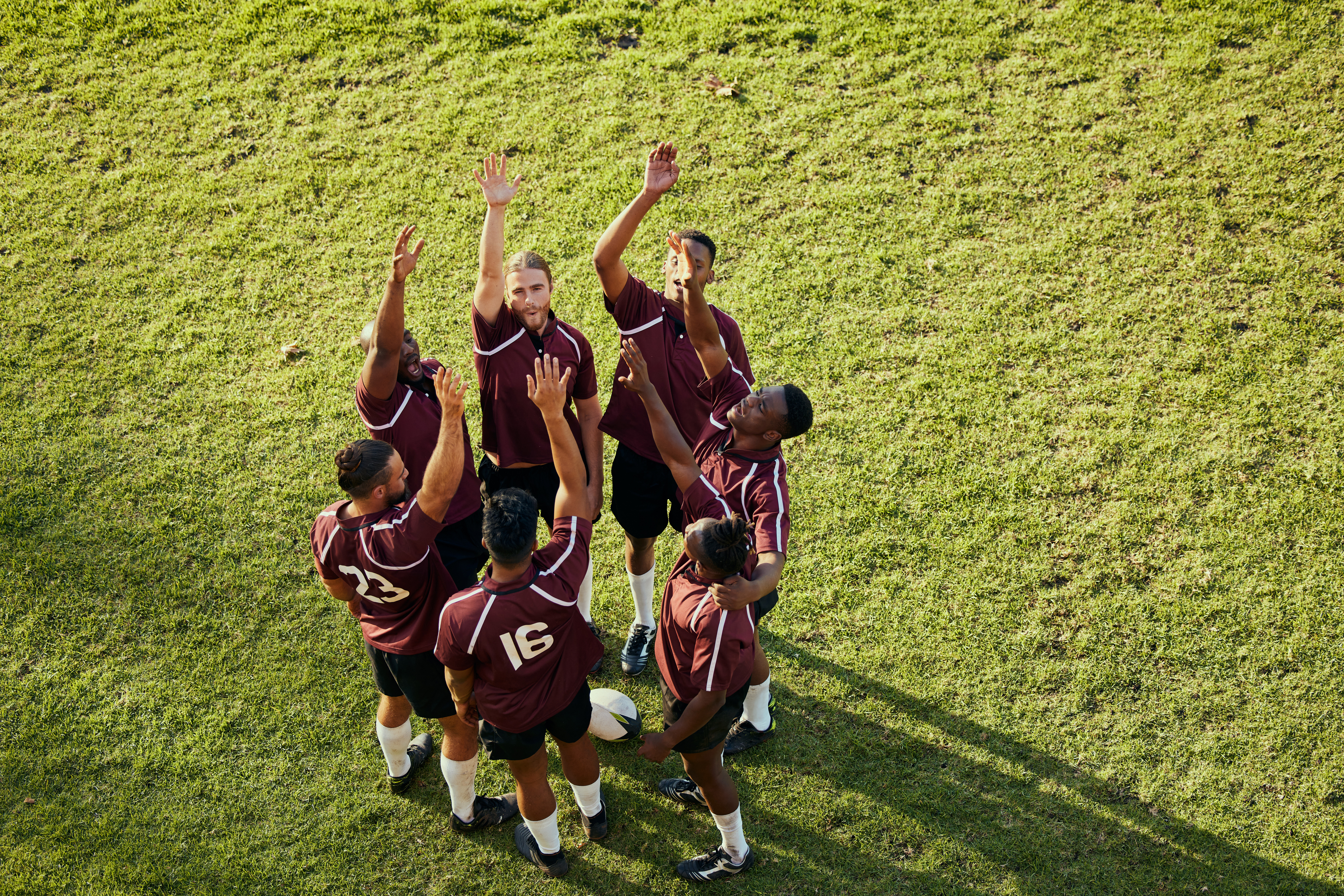 A team raising their hands and celebrating in a circle