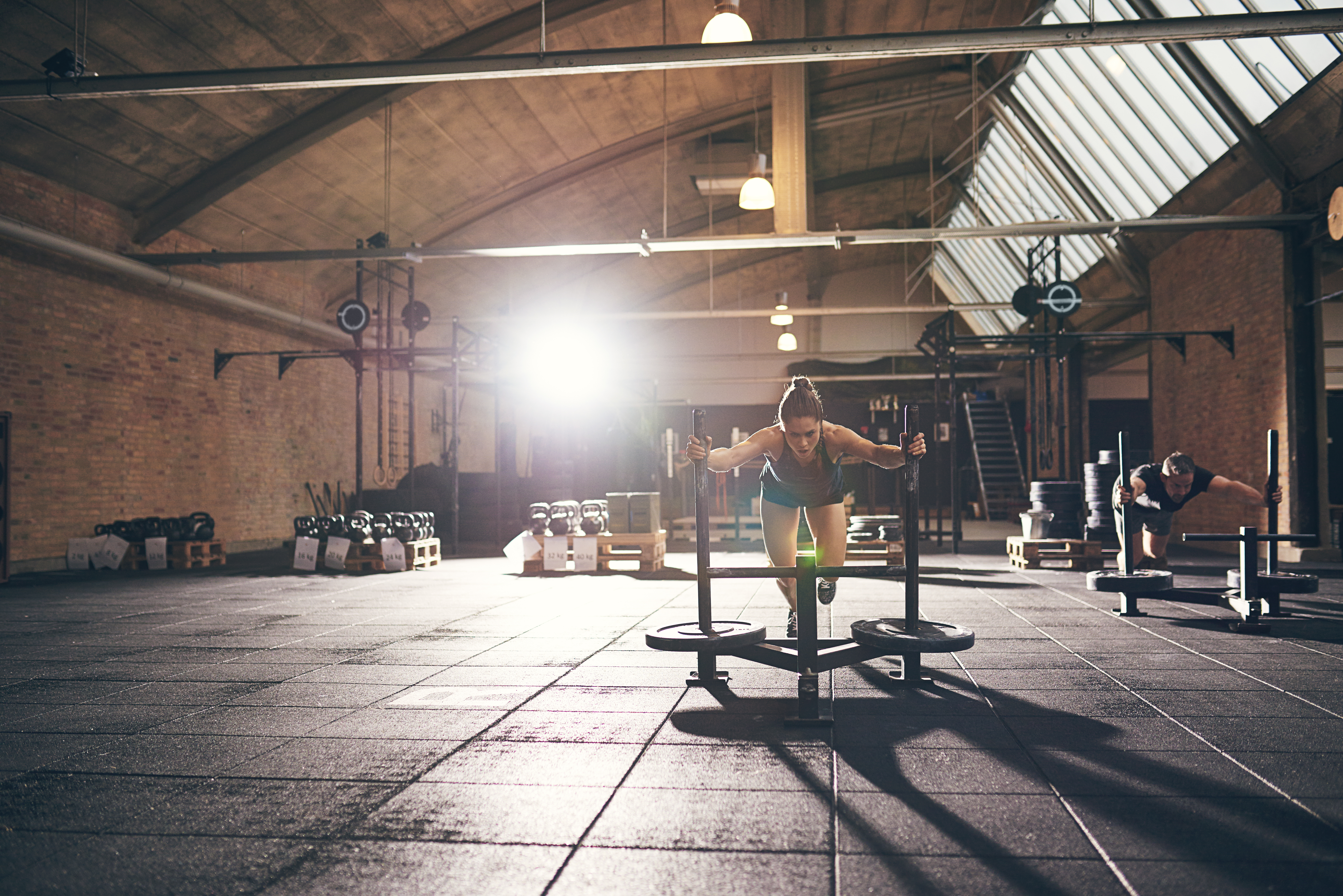 Woman in the gym pushing a sled 