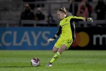 Sophie Baggaley kicking a football in Manchester United Yellow Kit